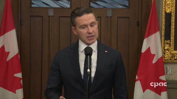 Conservative Leader Pierre Poilievre stands before a mic answering a question. CPAC is in the bottom right