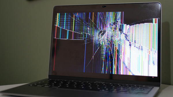 A laptop with a broken screen sitting on a table