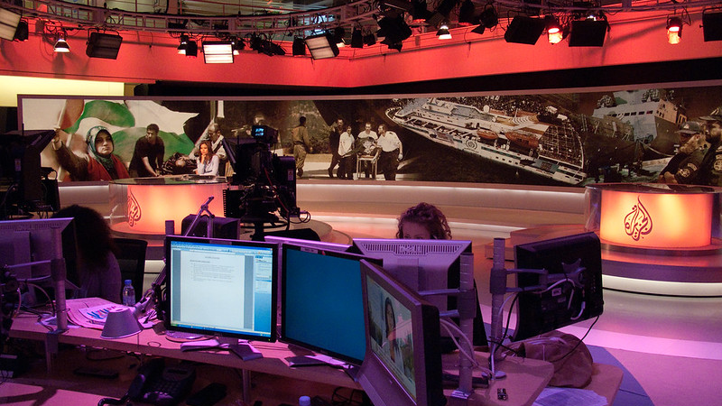 A picture of the Al Jazeera English newsroom with cameras, monitors and a worker present in the foreground