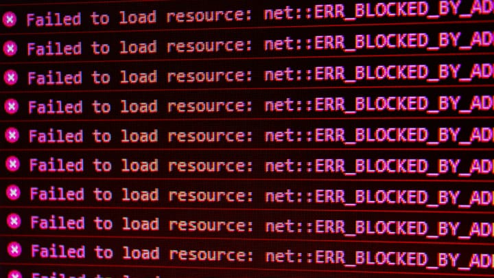 A computer screen showing the error "X Failed to load resource: net :: ERR_BLOCKED_BY_AD" repeatedly